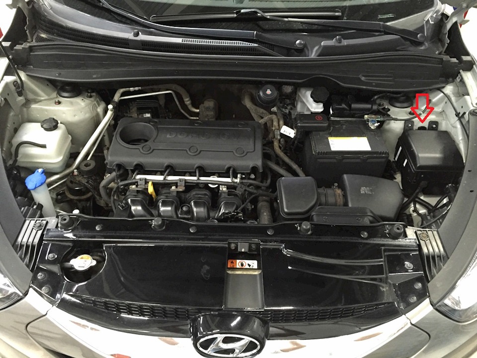 Отжать фиксатор крышки монтажного блока в подкапотном пространстве на автомобиле Hyundai ix35